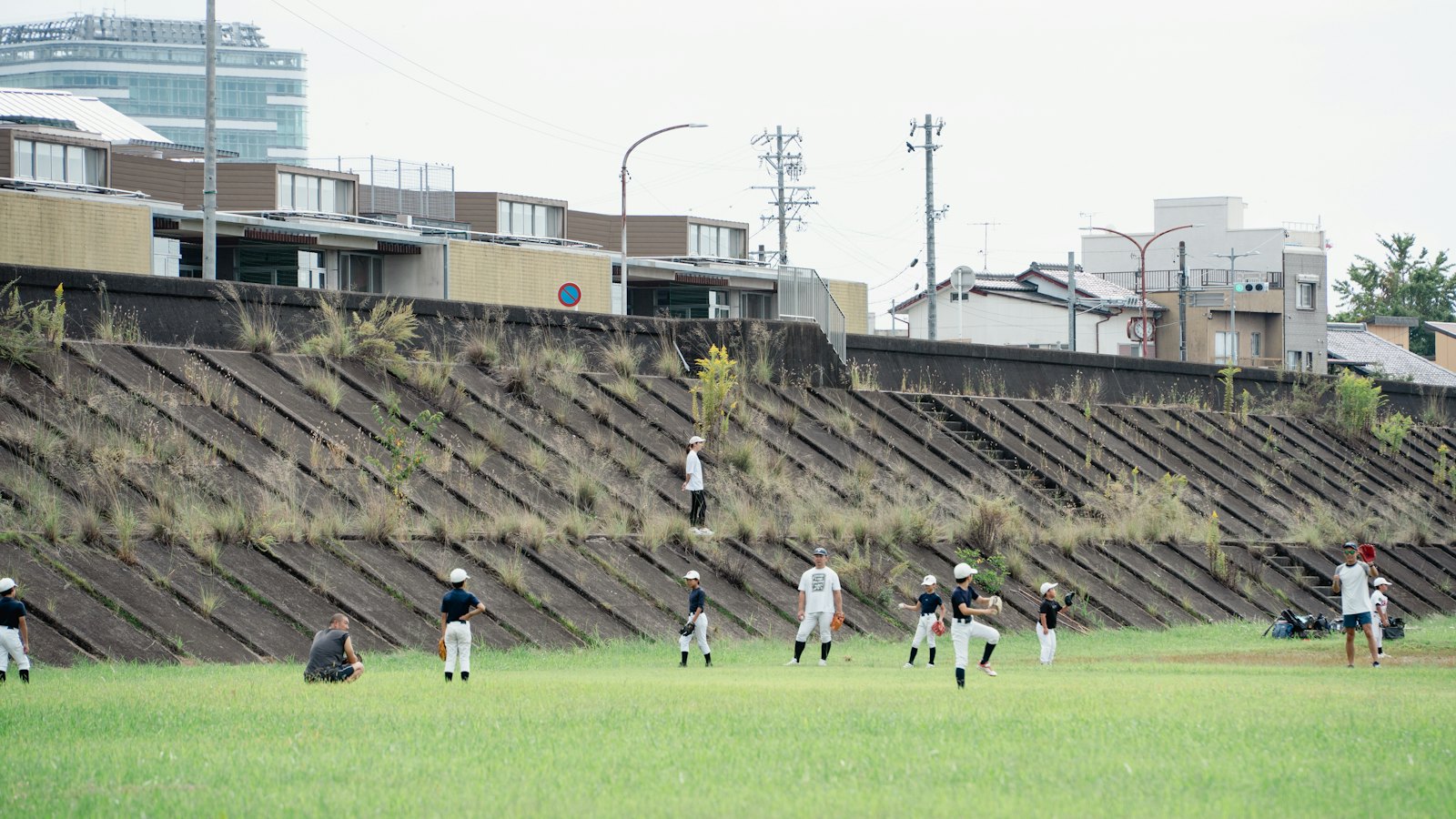 夕方のグラウンドで練習する少年野球チーム