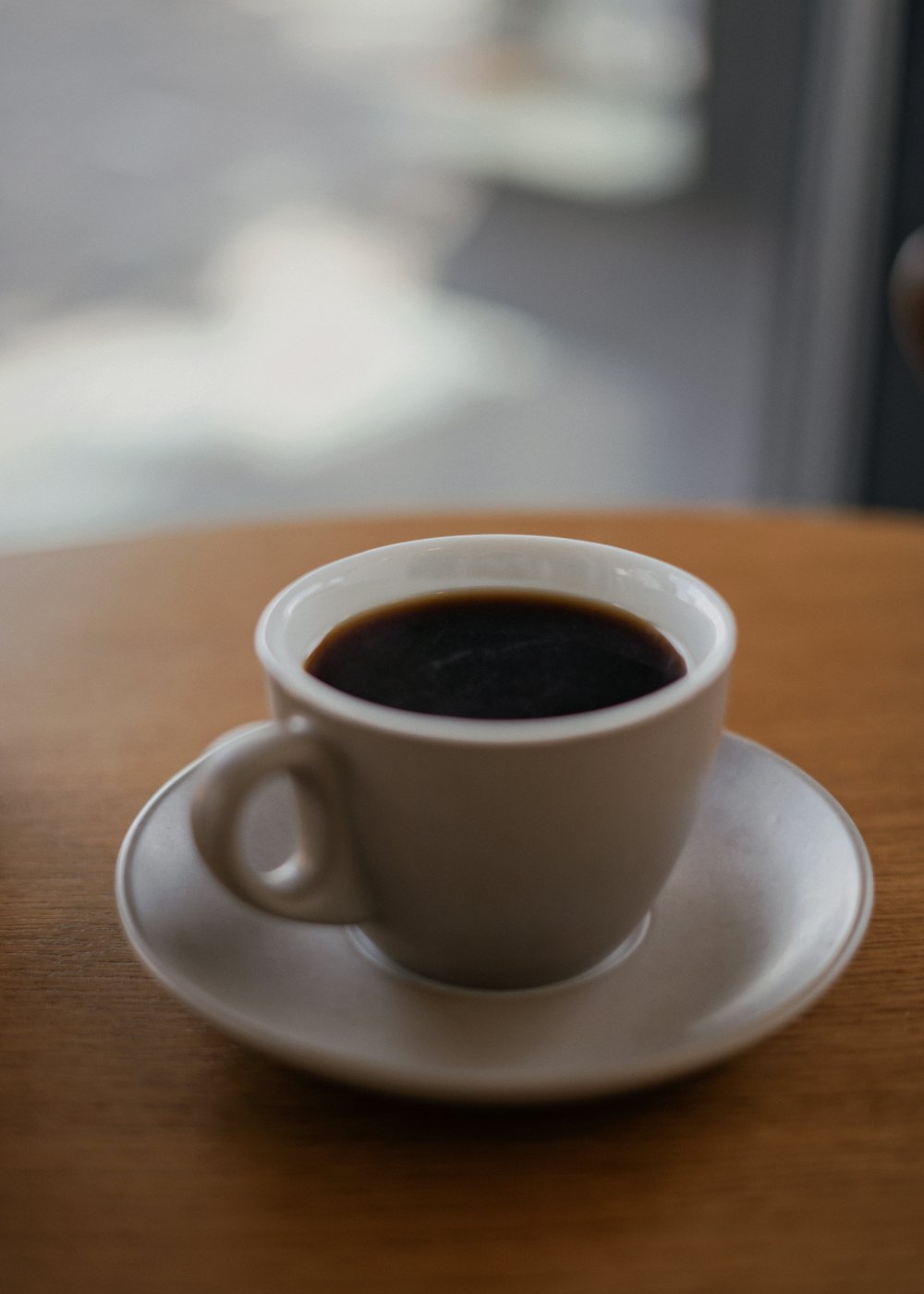 木のテーブルに置かれた一杯のコーヒー